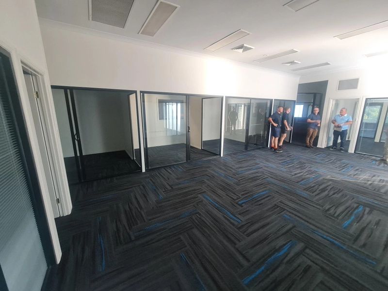 Empty office space with glass-walled cubicles