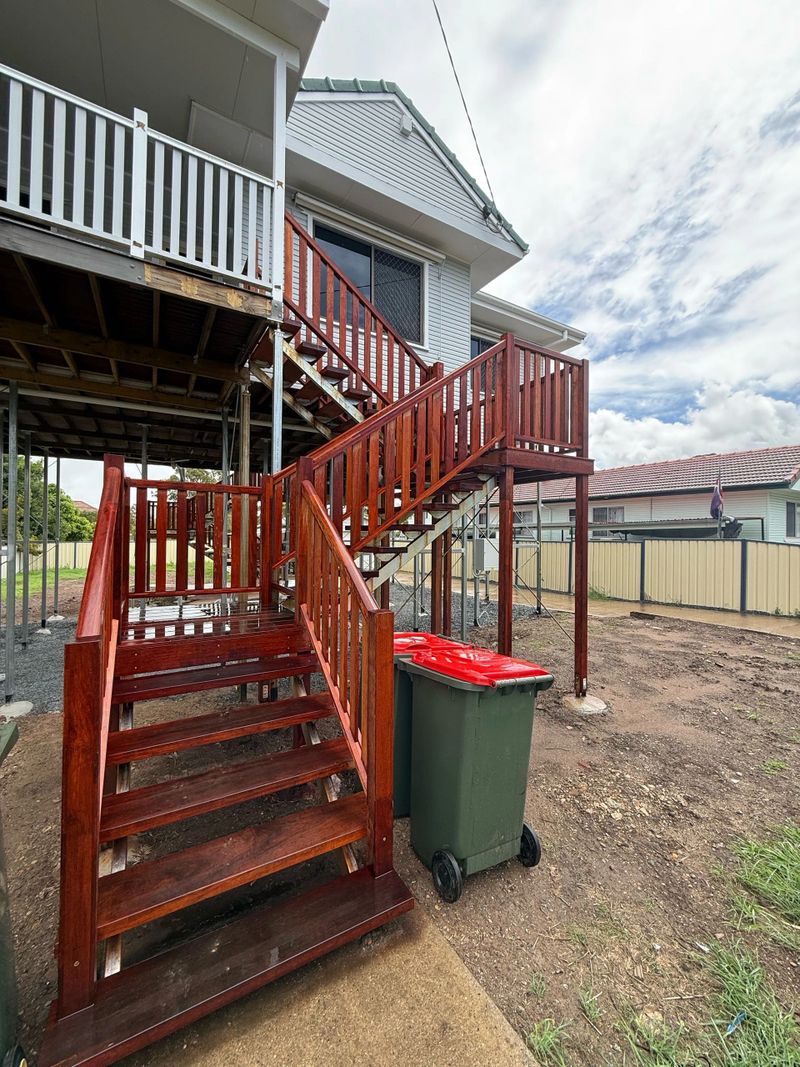 Newly stained wooden outdoor stairs attached to a house